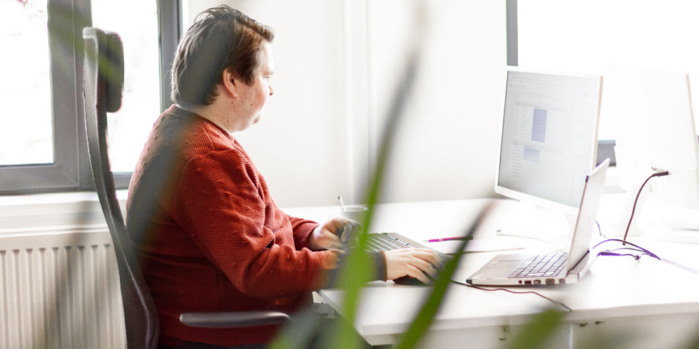 Online marketeer werkt achter een computer en analyseert marketingdata op kantoor.