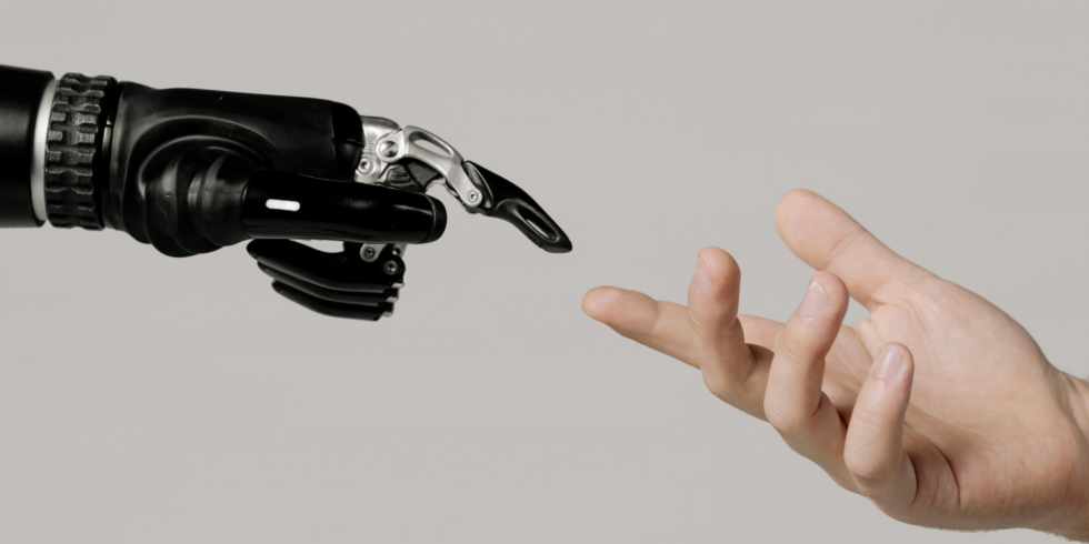 “Een robotische hand en een menselijke hand die naar elkaar reiken tegen een neutrale achtergrond.