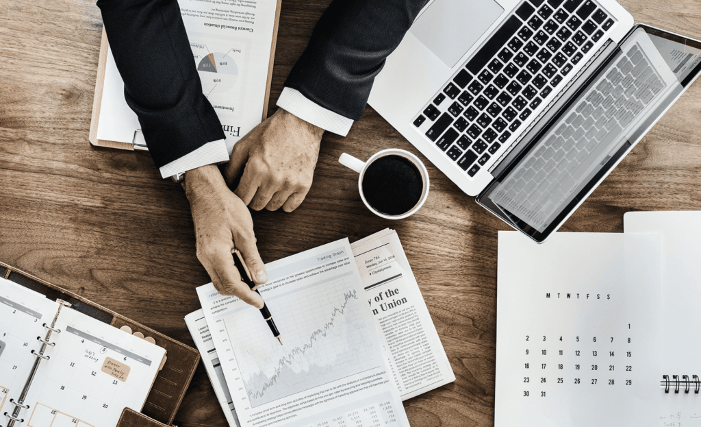 Bureau met laptop, kalender en rapport met grafieken voor bedrijfsanalyse.