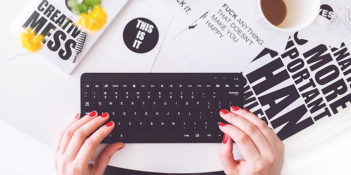 vrouw typt op toetsenbord met daaromheen allemaal quotes