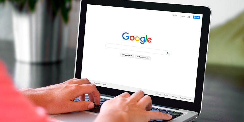 Persoon gebruikt een laptop met Google zoekpagina open.