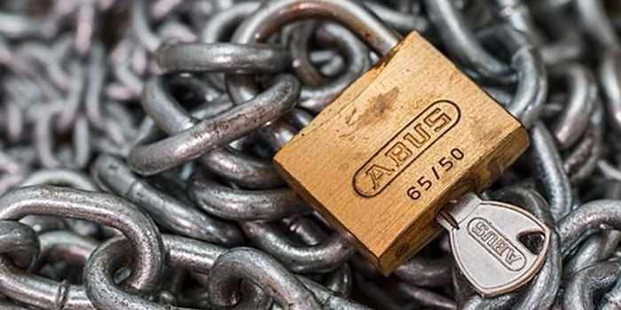 Metalen ketting met ABUS-hangslot en sleutel in het slot.